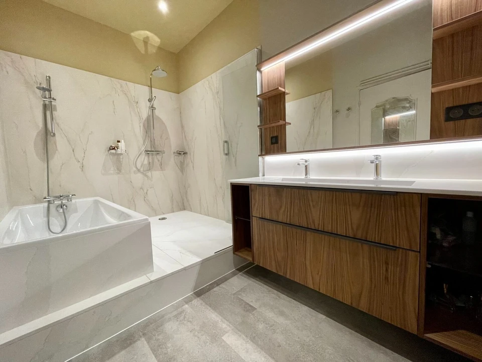 Salle de bain moderne avec lavabo blanc rond posé sur plan de travail en bois vieilli